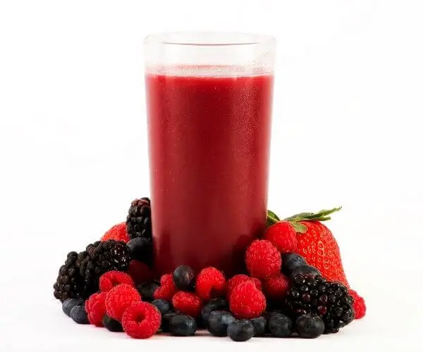 Fruit surrounding a glass of frozen juice