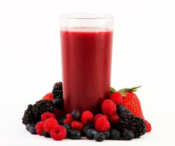 Fruit surrounding a glass of frozen juice