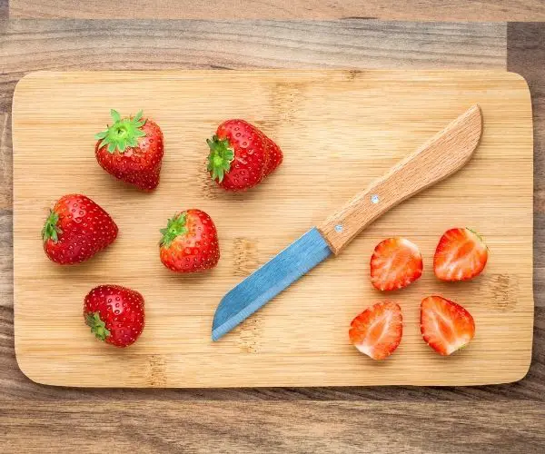 prepping thawed strawberries before juicing