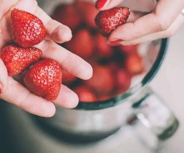 A blender does allow you to blend in frozen fruits and other solids into your shakeology, but that isn't 100% necessary. This is an image of strawberries being placed into a blender.