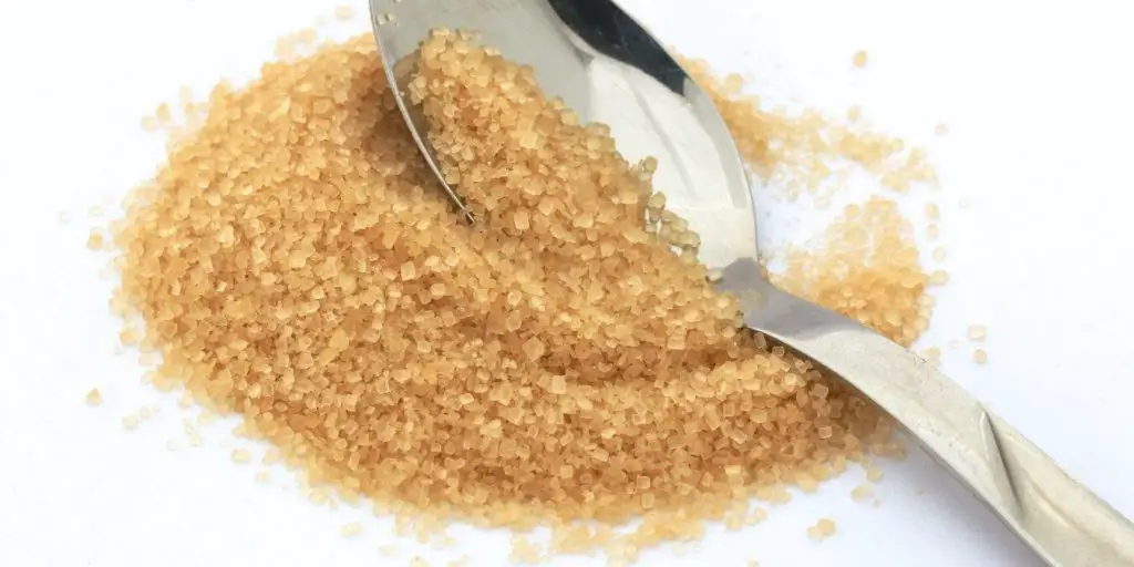 raw sugar being scooped by spoon