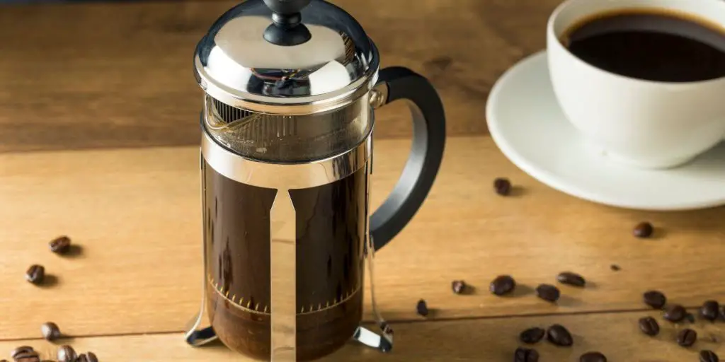 french press with a cup of coffee