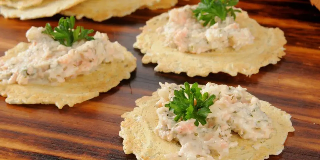 smoked salmon dip on crackers with parsley on top