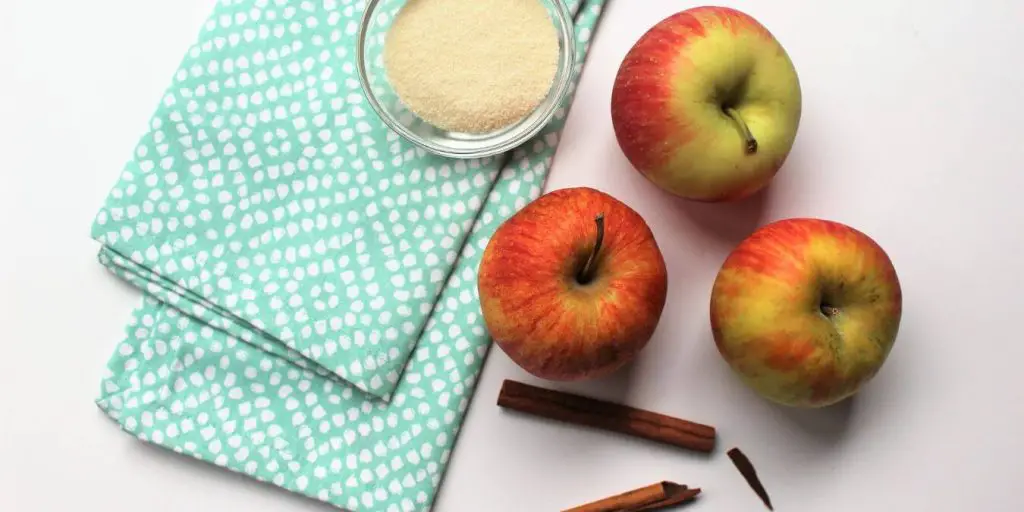 Apples, sugar and cinnamon displayed as ingredients to make applesauce without a food mill.